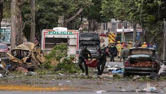 Police officers carry debris from the site of a bomb explosion in cali, Colombia on August 21 2025. AFP