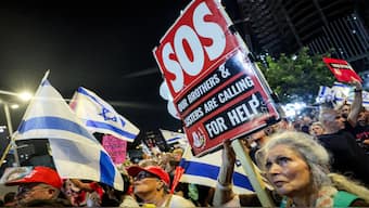 A protester holds a sign during a demonstration organised by the families of the Israeli hostages taken captive in the Gaza Strip since the October 2023 calling for action to secure their release and a ceasefire in the war against Hamas, outside the Defence Ministry headquarters in Tel Aviv, on August 23, 2025. AFP