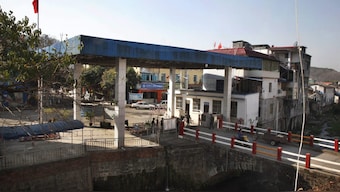 Chinese security officers stand at a border gate between Kachin rebel-controlled Laiza in Myanmar's north and China's western Yunnan. File image/ AP