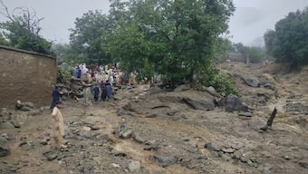 In this photo released by Rescue 1122 Emergency Department, rescue workers and local residents gather at the site of a massive cloudburst led to flash flooding in Salarzai, Pakistan. AP
