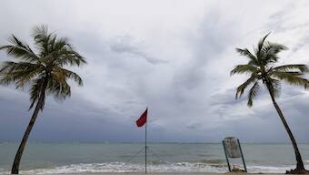A red flag warns of dangerous waves on an empty beach in San Juan, Puerto Rico, after Hurricane Erin passed by near the island. AP