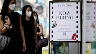 A sign advertising job openings is seen while people walk into the store in New York City, New York, U.S., August 6, 2021. Reuters File