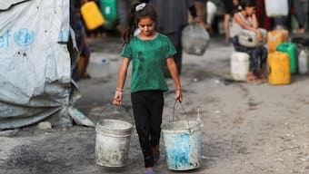 A Palestinian girl carries buckets of water amid shortages, in Gaza City, August 6, 2025. Reuters