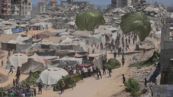 Palestinians rush to collect humanitarian aid airdropped by parachutes into Gaza City, northern Gaza Strip, August 7, 2025. File Image/AP
