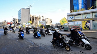 Men carry Hezbollah flags while riding on two wheelers, at the entrance of Beirut's southern suburbs, in Lebanon, on November 27, 2024. Reuters File