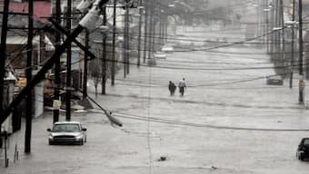 People walk down flooded street as Hurricane Katrina hits New Orleans, Louisiana. File image/AP