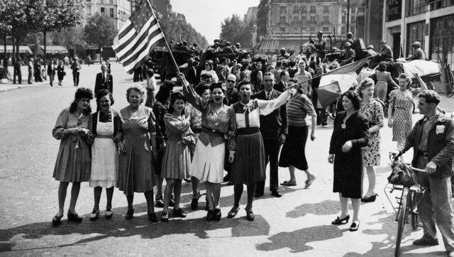 French civilians with their hastily made American and French flags sing the 