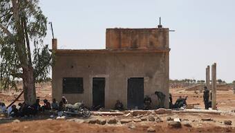 Bedouin fighters rest in the shade of a house as Syrian government security forces block them from entering Sweida province, in Busra al-Harir village, southern Syria, Sunday, July 20, 2025. (AP Photo/Ghaith Alsayed)

