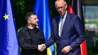 Ukrainian President Volodymyr Zelensky (L) is welcomed by German Chancellor Friedrich Merz upon arrival in the garden of the chancellery in Berlin to join a video conference of European leaders with the US President on the Ukraine war ahead of the summit between the US and Russian leaders, on August 13, 2025. Image- AFP