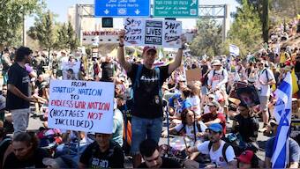 Families and supporters of Israelis held hostage by Hamas militants in Gaza since the October 7, 2023 attacks, hold placards and national flags during a protest calling for government action to secure their release in Jerusalem on August 17, 2025.