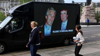 People walk next to a mobile Ad Van that displays a photograph of US President Donald Trump and disgraced financier and sex offender Jeffrey Epstein, in protest of the visit of US President Donald Trump in Aberdeen, Scotland, UK, July 28, 2025. File Image/Reuters