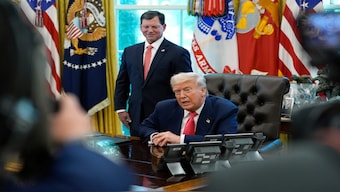 President Donald Trump speaks with reporters as Social Security Commissioner Frank Bisignano listens during an event in the Oval Office to mark the 90th anniversary of the Social Security Act, on Thursday, in Washington. AP