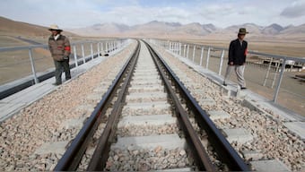 Two workers walk along the Qinghai-Tibet Railway as they check the railway track in Dangxiong county of the Tibet Autonomous Region, April 20, 2007. File Photo/Reuters