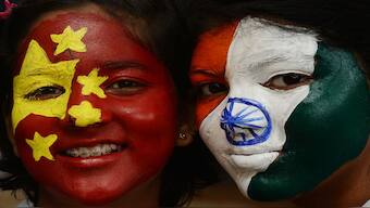 Indian school students pose with their faces painted with India's (R) and China's national flags. Relations between the two countries are on the mend. File image/AFP