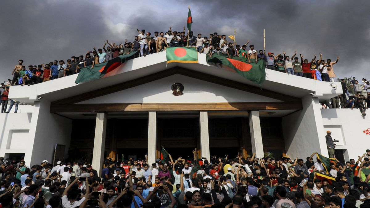 Anti-government protesters display Bangladesh's national flag as they storm Prime Minister Sheikh Hasina's palace in Dhaka on August 5, 2024. File image/AFP Anti-government protesters display Bangladesh's national flag as they storm Prime Minister Sheikh Hasina's palace in Dhaka on August 5, 2024. File image/AFP