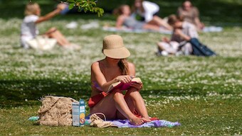 A woman reads a book in St James’s Park, amid spring warm weather, in London, Britain. Reading is experiencing a slow death across the world. Representational image/Reuters