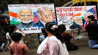 People walk by as students complete artwork of US President Donald Trump and Prime Minister of India Narendra Modi, in Mumbai. On August 27, Trump's 50% tariffs on India will come into effect. PTI