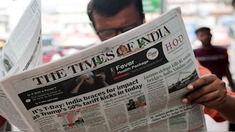 A man reads The Times of India newspaper, with the lead story on US tariffs on most Indian goods, in the old quarters of Delhi. File image/Reuters