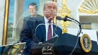 Apple CEO Tim Cook gave a glass piece made by Corning, with President Trump’s name printed across the top. AP