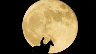 A man riding his horse is photographed with the full moon in the background, in Arguineguin on Gran Canaria Island, Spain. Reuters
