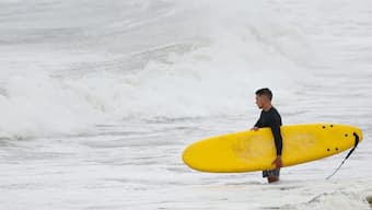 A surfer looks at waves during Hurricane Erin, which is expected to trigger a dangerous storm surge and tropical storm conditions along the East Coast, on the Atlantic Ocean in Long Beach, New York, US on August 21, 2025. Reuters