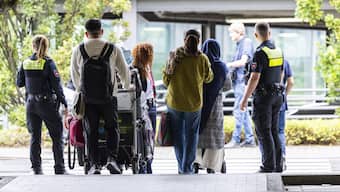Afghan nationals walk past German policemen to board a bus after they landed at the airport in Hannover-Langenhagen, northwestern Germany. AFP