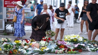 A woman places flowers next to other tributes displayed at the site of the Gloria funicular accident in Lisbon on September 5, 2025. 16 people were killed and 21 injured in a funicular accident on September 3, 2025. AFP