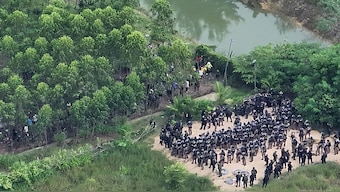 This handout aerial photo taken and released by the Royal Thai Army on September 17, 2025 shows Thai army and police (bottom) facing Cambodian people in a disputed area along the Cambodia-Thailand border, as seen from Sa Kaeo province. AFP