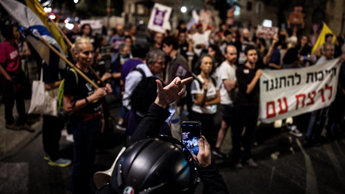 A man films himself holding up his middle finger at protesters during a demonstration against the war in Gaza and calling for the release of hostages in Jerusalem on September 20, 2025. AFP A man films himself holding up his middle finger at protesters during a demonstration against the war in Gaza and calling for the release of hostages in Jerusalem on September 20, 2025. AFP