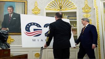 A military aide places a G20 sign in the Oval Office as Treasury Secretary Scott Bessent walks past as President Donald Trump speaks in the Oval Office of the White House, Friday, Sept. 5, 2025, in Washington. AP