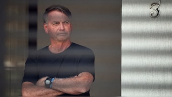Brazil's former President Jair Bolsonaro stands at his home while under house arrest, ordered by Supreme Court Justice Alexandre de Moraes, as he awaits trial over an alleged plot to overturn the 2022 election, in Brasilia, Brazil, August 14, 2025. File Image/Reuters