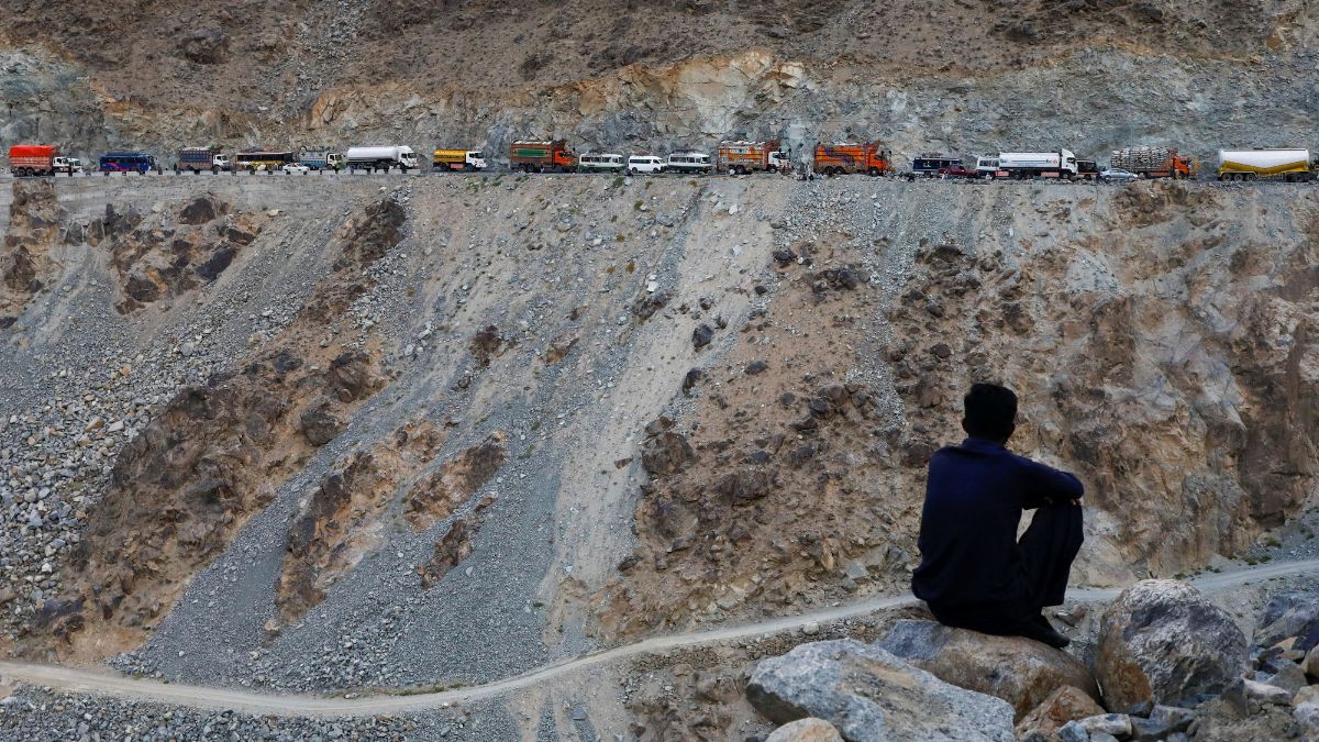 A man sits with the stranded vehicles, in the background, after residents blocked the Karakoram Highway during a protest demanding compensation against their land utilised on Hydro Power Projects near Basha, Pakistan, October 6, 2023. File Image/Reuters A man sits with the stranded vehicles, in the background, after residents blocked the Karakoram Highway during a protest demanding compensation against their land utilised on Hydro Power Projects near Basha, Pakistan, October 6, 2023. File Image/Reuters
