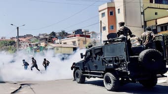 A protester throws back a tear gas canister lobbed by Malagasy riot police during a demonstration denouncing frequent power outages and water shortages, near the University of Antananarivo, Madagascar on Monday. Reuters