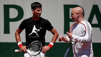 Novak Djokovic and Andre Agassi, who was part of his team at the time, discuss tactics during the 2017 French Open. Reuters