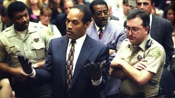 OJ Simpson holds his hands up to the jury during testimony in Los Angeles Thursday June 15, 1995, to show the bloody gloves the prosecution says he wore when he murdered Nicole Brown Simpson and Ron Goldman. Simpson put the gloves on at the request of the prosecution, who accused him of faking a struggle to pull them on. In the background are defence attorneys Johnnie Cochran Jr., third from right and Robert Shapiro, right. File Image/Reuters