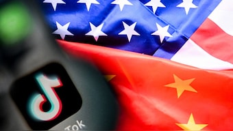 (FILES) A photo taken on April 10, 2025 shows the Chinese social networking service TikTok's logo on a smartphone screen (L) and US' and China flags combo illustration on a laptop screen in Frankfurt am Main, western Germany. Image- AFP