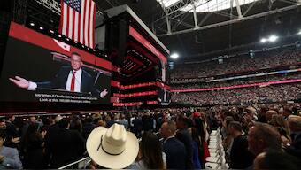 Attendees listen to right-wing commentator Benny Johnson speak during the public memorial service for right-wing activist Charlie Kirk at State Farm Stadium in Glendale, Arizona, on September 21, 2025. (Photo by Patrick T. Fallon / AFP)