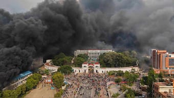 Protesters celebrate at the Singha Durbar, the seat of Nepal's government’s various ministries and offices, after it was set on fire. AP
