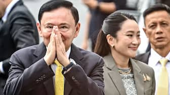 Thailand's former Prime Minister Thaksin Shinawatra arrives with his daughter Thailand's sacked prime minister Paetongtarn Shinawatra (R) at the Supreme Court in Bangkok. AFP File