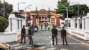 Army personnel stand near charred remains as they patrol along a street outside the torched President House in Kathmandu on September 10, 2025. AFP