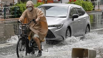 Sudden deluge of rain floods some streets and halts air and rail traffic in Tokyo. AP