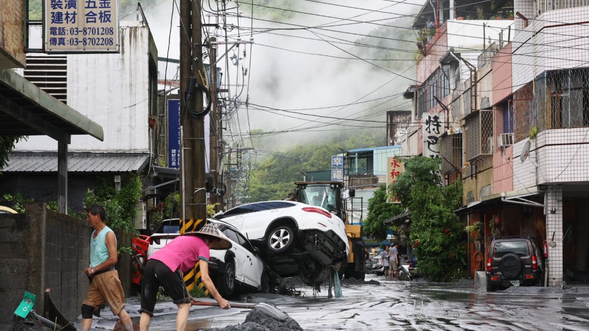 Residents clear mud from their property, while damaged cars are seen in the background, in Hualien on September 24, 2025, following the bursting of a barrier lake. AFP Residents clear mud from their property, while damaged cars are seen in the background, in Hualien on September 24, 2025, following the bursting of a barrier lake. AFP