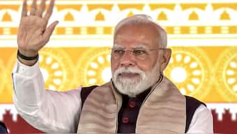 PM Narendra Modi greets the gathering during the foundation stone laying and inauguration of various development projects at a public rally, in Jharsuguda, Odisha. Image Courtesy: @NarendraModi/X via PTI Photo