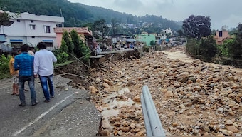Residents look at a portion of a road that was washed away after heavy rains triggered a cloudburst, in Dehradun, Uttarakhand, Tuesday, Sept. 16, 2025. PTI