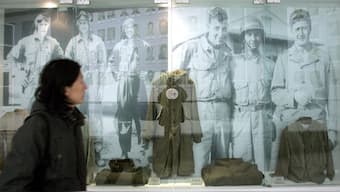A visitor walks past the images and old uniforms of the Flying Tigers from World War II, who were led by late General Claire L. Chennault at the Anti-Japanese War Museum in Dayi county in China's southwestern province of Sichuan, The museum holds more than 20,000 artifacts which exhibit the history of China's war of resistance against Japanese invasion during 1937 to 1945. File photo/AFP 