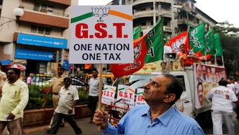 A man holds a placard supporting the Goods and Services Tax (GST) in Mumbai. Now, huge reforms have been brought to the GST structure. File image/Reuters