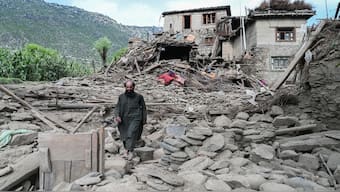 A man walks past a damaged house following earthquakes in the Mazar Dara village of Nurgal, a district of the Kunar Province, in Eastern Afghanistan, on September 1, 2025. More than 800 people have died and over 2,700 were injured  after a 6-magnitude earthquake, followed by at least five aftershocks felt hundreds of kilometers away. AFP