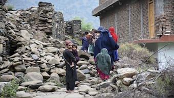 Local residents walk by a house destroyed by an earthquake that killed many people and destroyed villages in eastern Afghanistan, in Mazar Dara, Kunar province, Afghanistan.  File Image / AP