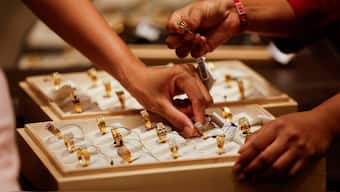 A salesperson shows a gold ring to customers at a jewellery showroom in Ahmedabad, India. Reuters