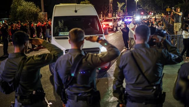 Israeli policemen salute as vehicles carrying bodies of four deceased hostages, who had been held in Gaza since the deadly October 7, 2023 attack, arrive at forensic institute. Reuters